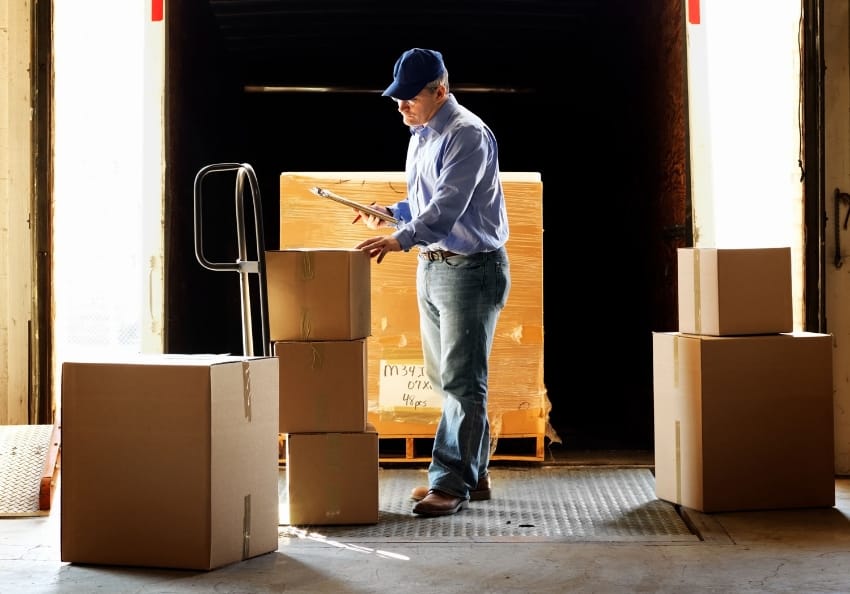 A person checks a shipping label on a box.